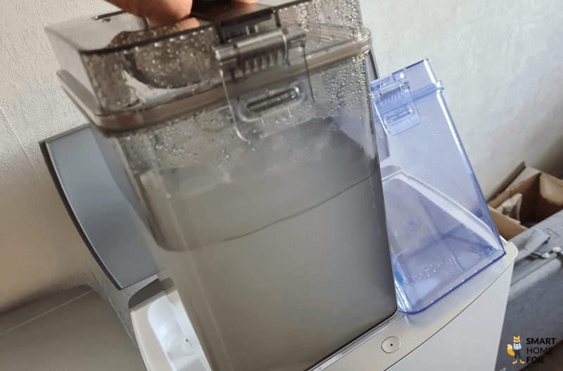 Der Schmutzwassertank der ECOVACS DEEBOT T20 OMNI Station wird in den Händen gehalten.